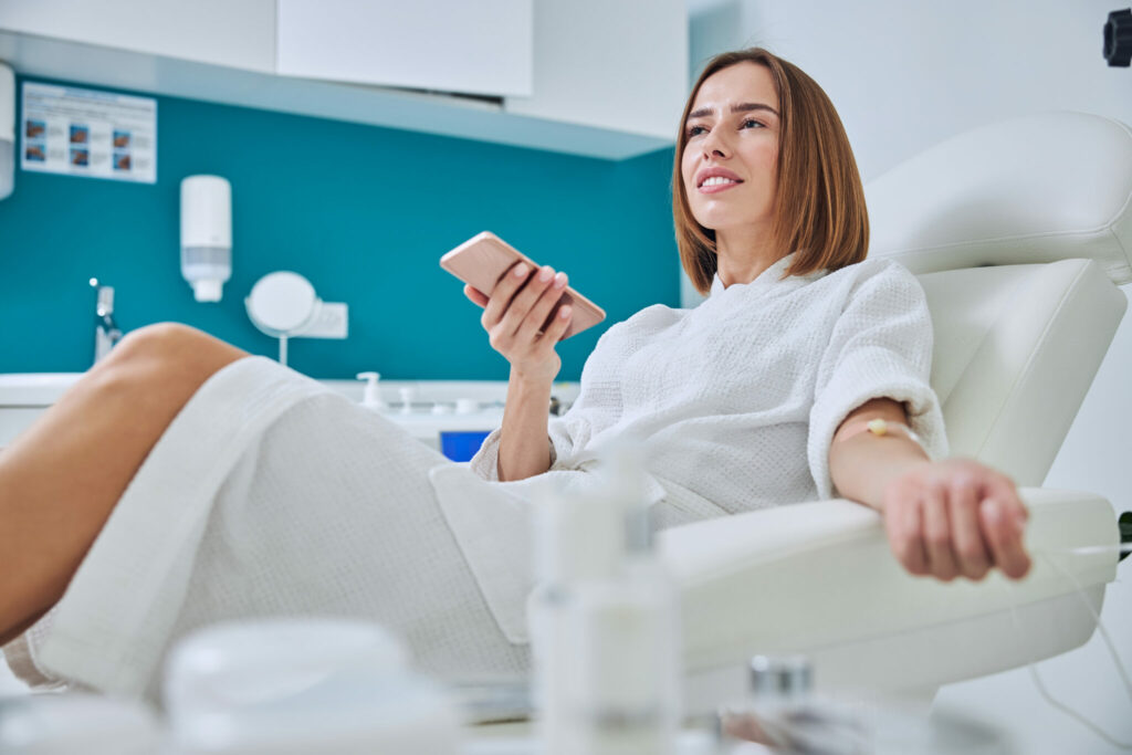 A young woman relaxes while receiving magnesium chloride IV therapy.