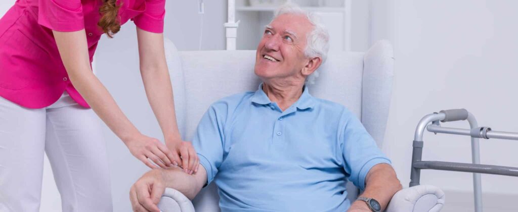 Nurse connecting IV vitamin therapy drip to senior patient.