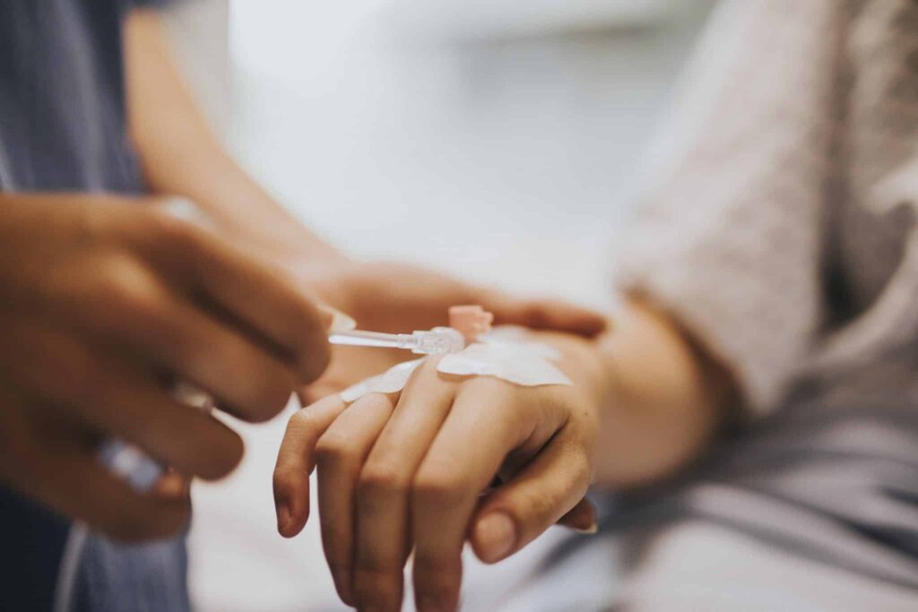 Nurse applying an IV drip to a patient.